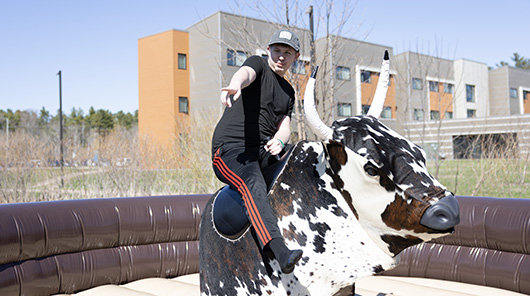 A student rides a mechanical bull during Block Bash 2025