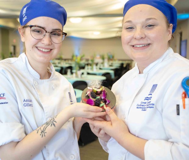 Two student chefs showing one of the desserts they made for the 2019 A Taste of Success culinary fundraiser