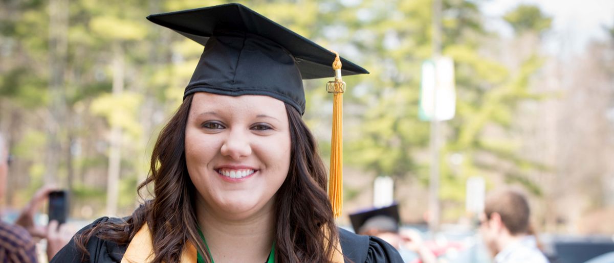 A woman in cap and gown at NMC's commencement ceremony.