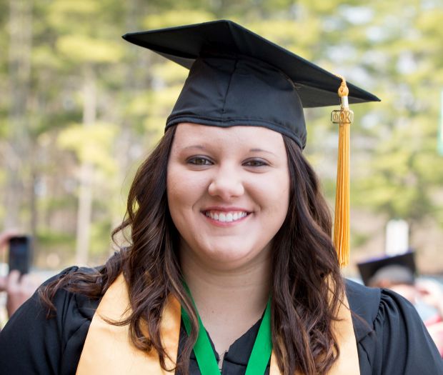 A woman in cap and gown at NMC's commencement ceremony