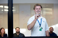 NMC photo of an aviation program student drawing on a clear whiteboard