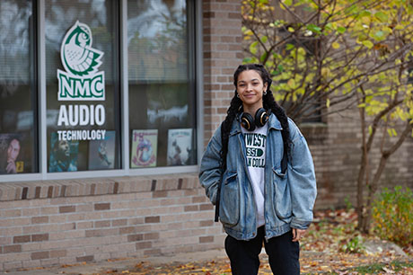 An Audio Technology program student in front of the Audio Tech classrooms