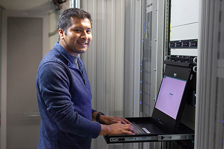 A Computer Information Technology (CIT) Cybersecurity program student works on a laptop