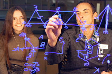AN Engineering program instructor explains an equation to a student