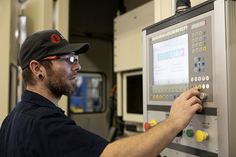 An NMC Manufacturing Technology program student works on a control panel