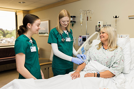 Nursing program students work with a patient