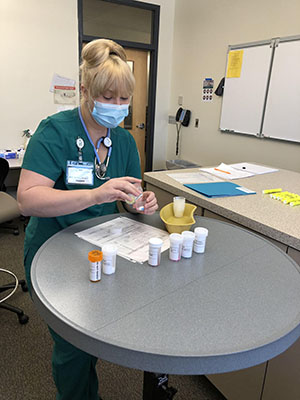 A Fundamentals of Nursing student calculates medication doses by working with orders, medication bottles, and specific patient scenarios