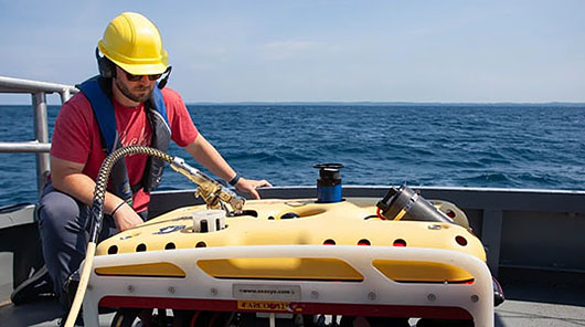 An NMC student prepares to deploy a remotely-operated vehicle aboard the research vessel Northwestern