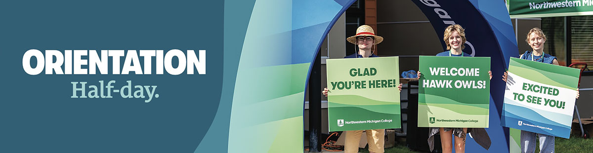 Three NMC students celebrate with placards during Welcome Week festivities