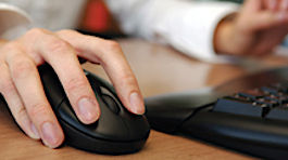 An NMC student working with a laptop and mouse