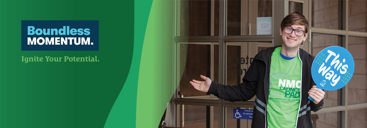 NMC student holding a directional sign during a Quick Start event