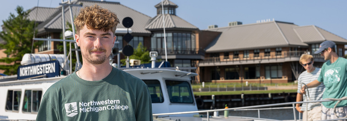 Students standing in front of the training vessel Northwestern on NMC's Great Lakes campus