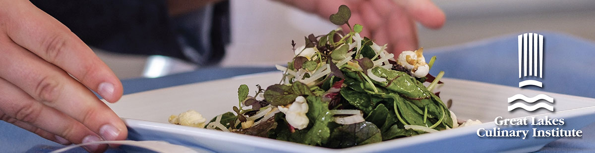 A Culinary Arts Program student serves a salad to a patron at Lobdell's Teaching Restaurant