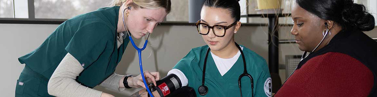 NMC nursing program students practice taking blood pressure in a lab exercise