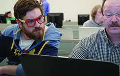 An NMC CIT Developer Program student works with an instructor on a programming exercise