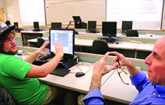 An NMC CIT Developer Program student works with an instructor on a computer application