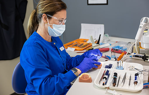 NMC Dental Assistant Program students work on a mannequin