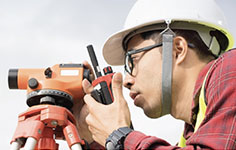 An engineer surveyor looks through a theodolite