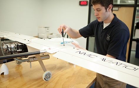 Photo of an NMC UAS Program student working on a large drone