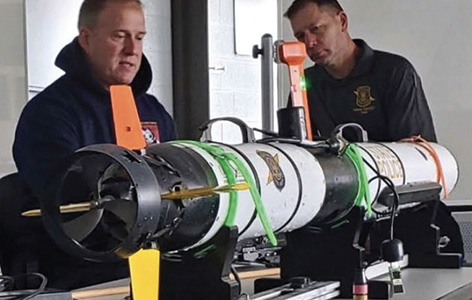 An NMC Marine Technology Program instructor and student inspect a remotely operated vehicle (ROV)