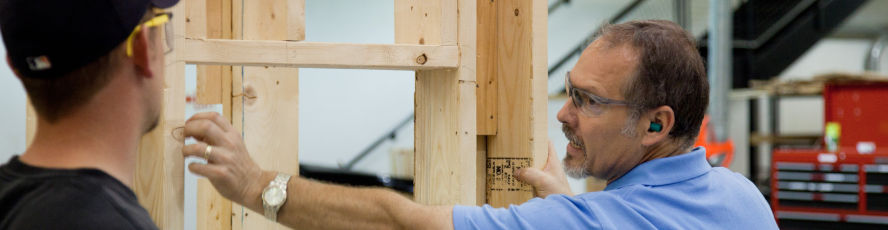 An NMC Carpentry Program instructor and student build a frame
