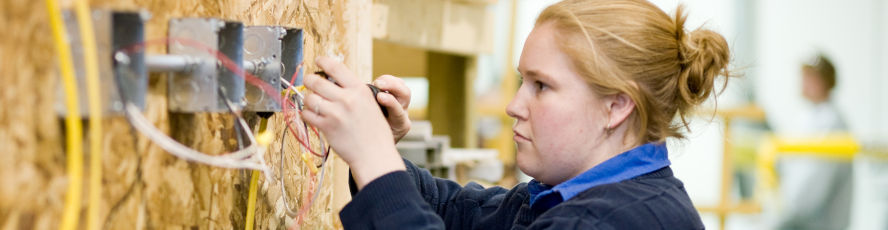 An NMC Construction Technology Electrical Technology Program student wires junction boxes
