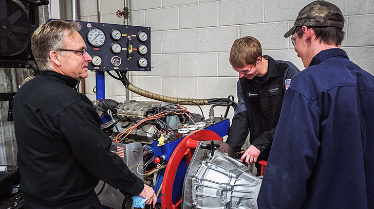 Wayne Moody and students working on a car transmission