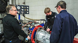 Wayne Moody and students working on a car transmission