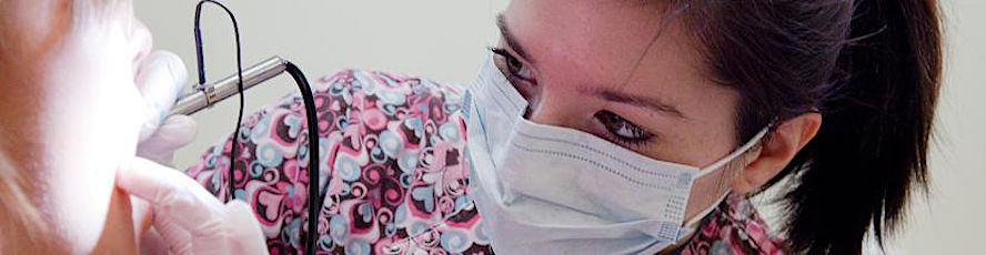 An NMC Dental Assistant program student performs a dental procedure