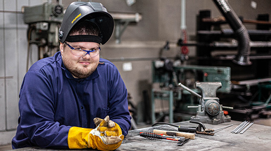 An NMC welding program student welds a pipe