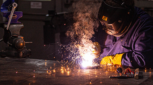 An NMC welding program student practices welding skills