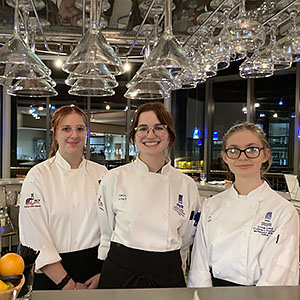 Three Great Lakes Culinary Institute Garde Manger students behind the bar at Lobdell's 