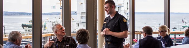 A Great Lakes Maritime Academy cadet serves patrons of the first GLMA Captain's Dinner