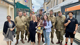 2022 France study abroad students pose with World War ll reenactors in Arromanches, France